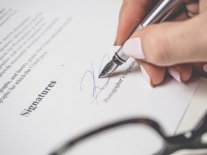 Woman signing beneficiary designation 